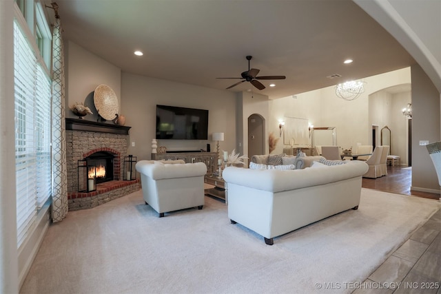 4314 S 132nd E Ave, Tulsa, OK 74134 - living room featuring a ceiling fan, a glass covered fireplace, arched walkways, recessed lighting, and a chandelier