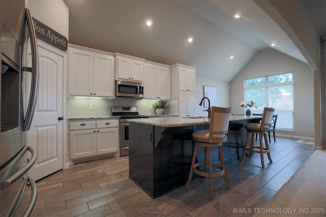 4314 S 132nd E Ave, Tulsa, OK 74134 - kitchen featuring appliances with stainless steel finishes, a sink, decorative backsplash, white cabinetry, and a kitchen island with sink