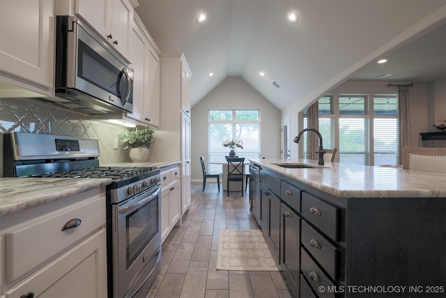 4314 S 132nd E Ave, Tulsa, OK 74134 - kitchen featuring appliances with stainless steel finishes, a sink, white cabinets, vaulted ceiling, and backsplash