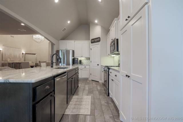 4314 S 132nd E Ave, Tulsa, OK 74134 - kitchen with stainless steel appliances, a sink, white cabinetry, light stone countertops, and lofted ceiling