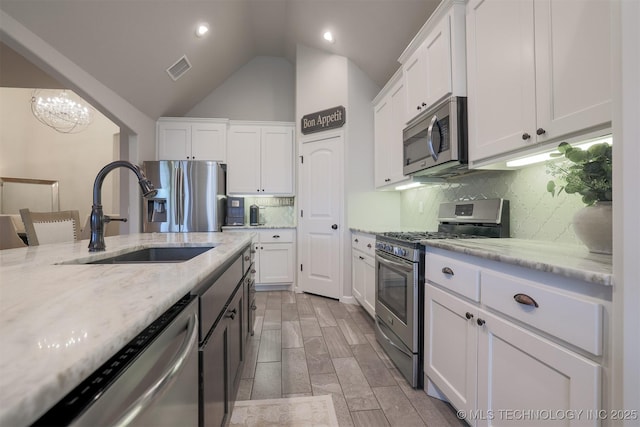 4314 S 132nd E Ave, Tulsa, OK 74134 - kitchen with appliances with stainless steel finishes, a sink, white cabinets, tasteful backsplash, and vaulted ceiling