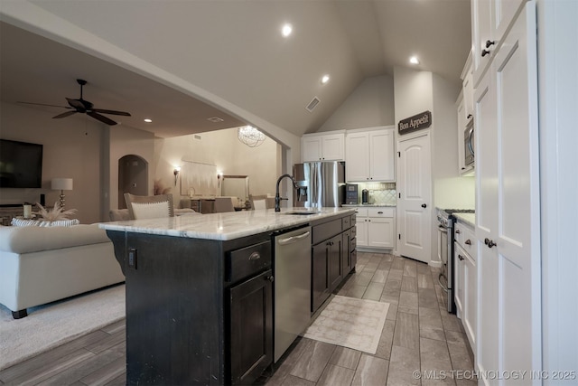 4314 S 132nd E Ave, Tulsa, OK 74134 - kitchen featuring stainless steel appliances, white cabinets, open floor plan, a sink, and decorative backsplash
