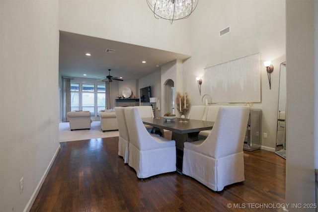 4314 S 132nd E Ave, Tulsa, OK 74134 - dining area featuring dark wood-type flooring, arched walkways, a chandelier, baseboards, and a high ceiling