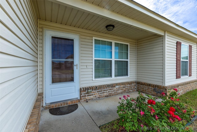 doorway to property with brick siding
