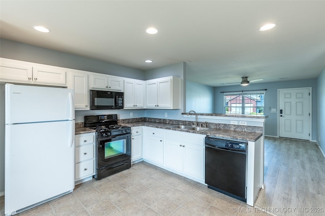 kitchen with black appliances, a sink, a peninsula, white cabinets, and recessed lighting