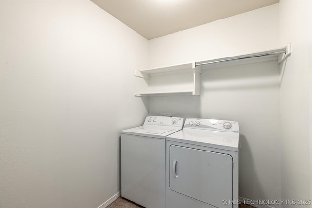 laundry area with washing machine and clothes dryer and baseboards