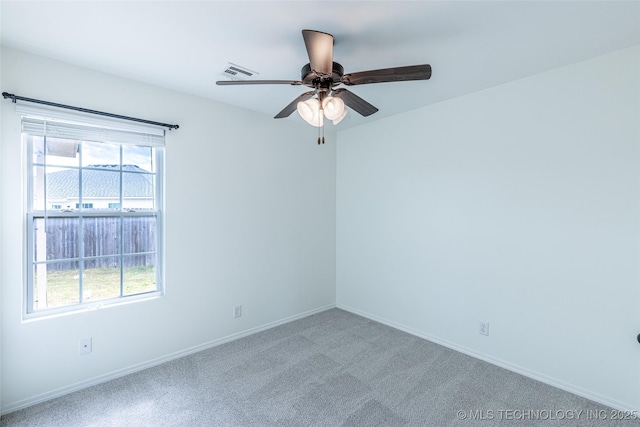 carpeted spare room featuring a ceiling fan and baseboards