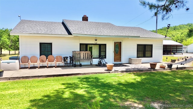 30190 W County Road 1240, Stigler, OK 74462 - back of property with a lawn, a patio area, roof with shingles, and a chimney