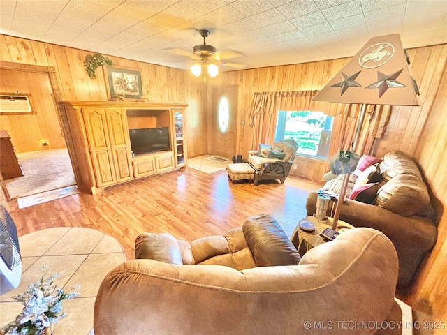 30190 W County Road 1240, Stigler, OK 74462 - living room with wood walls, light wood finished floors, a ceiling fan, and a wall mounted air conditioner