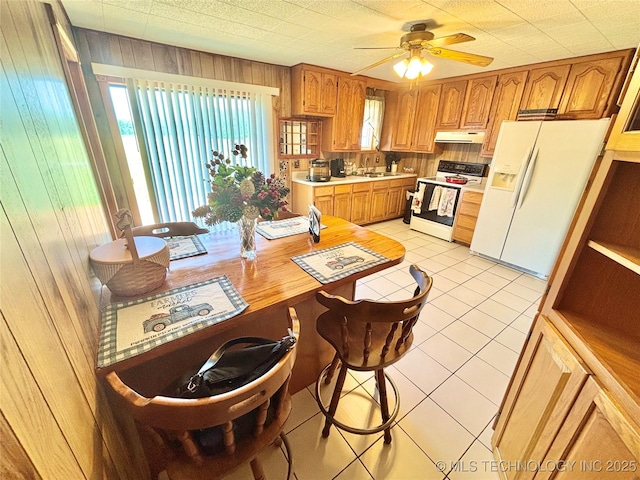 30190 W County Road 1240, Stigler, OK 74462 - kitchen featuring white appliances, under cabinet range hood, a sink, light countertops, and wooden walls