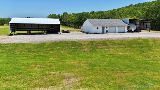 30190 W County Road 1240, Stigler, OK 74462 - view of outbuilding featuring gravel driveway, a garage, and a view of trees