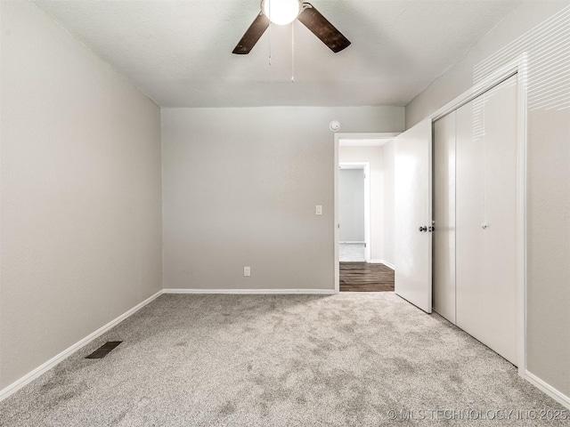 unfurnished bedroom featuring carpet flooring, a closet, baseboards, and ceiling fan