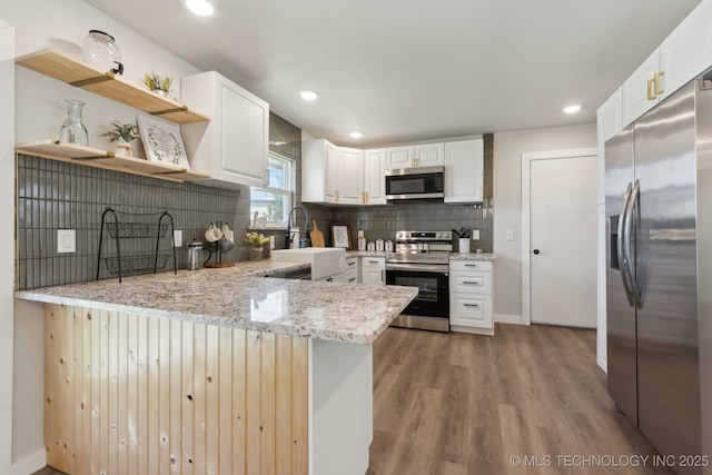 425 Mulberry Ave, Afton, OK 74331 - kitchen with stainless steel appliances, a peninsula, wood finished floors, open shelves, and decorative backsplash