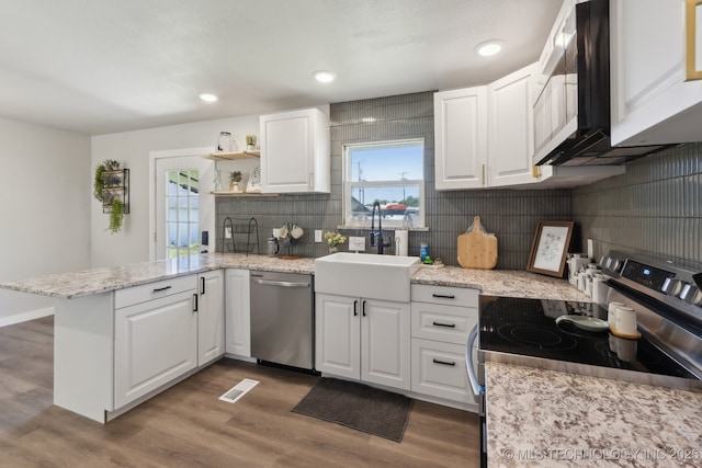 425 Mulberry Ave, Afton, OK 74331 - kitchen with stainless steel appliances, a peninsula, white cabinets, wood finished floors, and recessed lighting