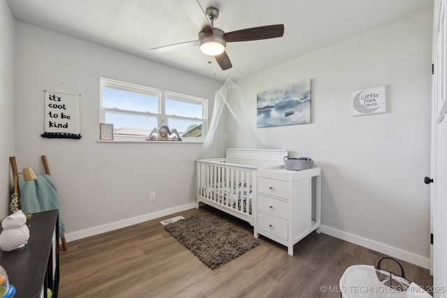 425 Mulberry Ave, Afton, OK 74331 - bedroom featuring a nursery area, wood finished floors, baseboards, and a ceiling fan