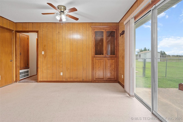 68 W Youth Cp, Healdton, OK 73438 - spare room with ceiling fan, wooden walls, baseboards, and light carpet