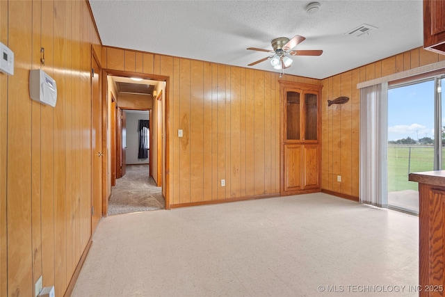 68 W Youth Cp, Healdton, OK 73438 - empty room with wooden walls, a ceiling fan, a smoke detector, light flooring, and baseboards