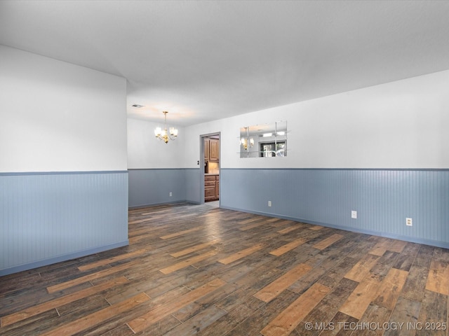 1044 Meadow Dr, Bartlesville, OK 74006 - empty room with a chandelier, wood-type flooring, and wainscoting