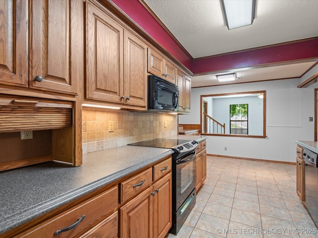 1044 Meadow Dr, Bartlesville, OK 74006 - kitchen featuring black appliances, backsplash, brown cabinets, and baseboards