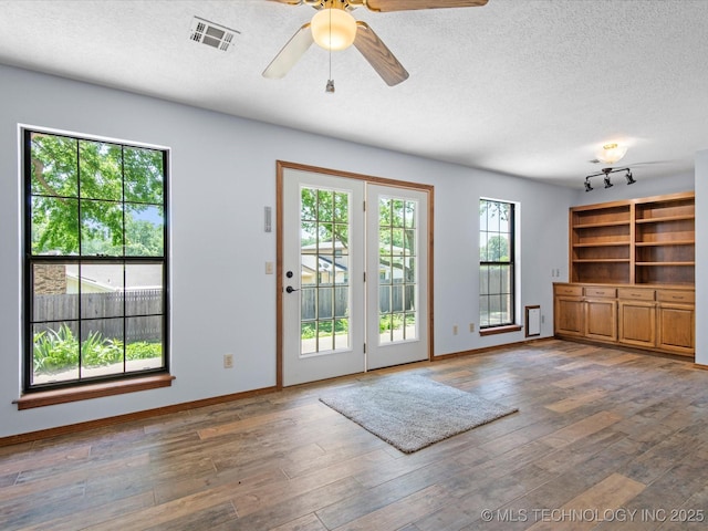 1044 Meadow Dr, Bartlesville, OK 74006 - entryway with wood finished floors, a textured ceiling, a ceiling fan, and baseboards