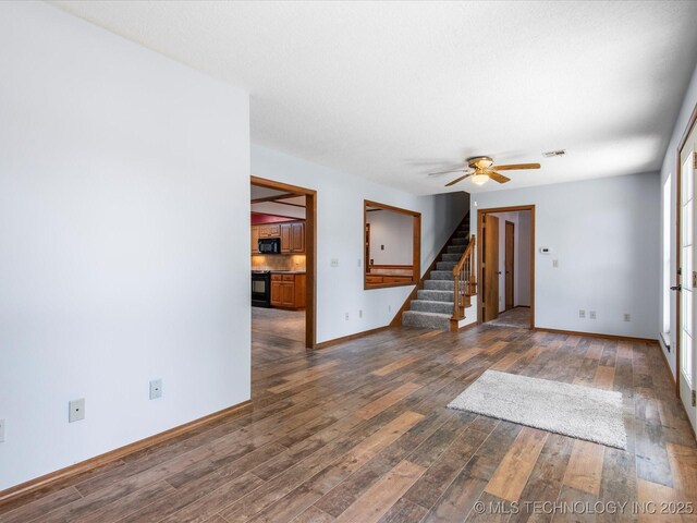 1044 Meadow Dr, Bartlesville, OK 74006 - empty room featuring stairs, dark wood-style flooring, baseboards, and ceiling fan