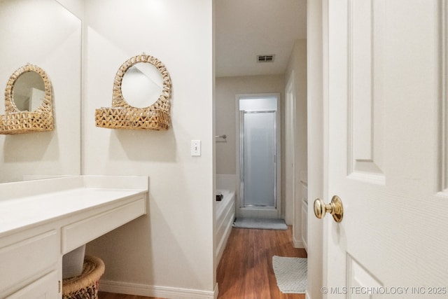7646 S Fulton Ave, Tulsa, OK 74136 - full bathroom featuring wood finished floors, a shower with shower door, baseboards, and vanity