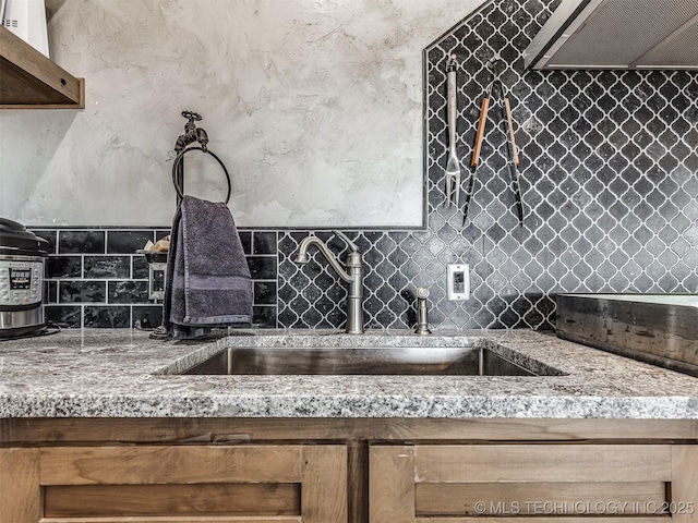 29550 S 4240th Rd, Inola, OK 74036 - kitchen with wall chimney exhaust hood, tasteful backsplash, a sink, and light stone counters