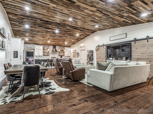 29550 S 4240th Rd, Inola, OK 74036 - living room with a barn door, wooden walls, dark wood-type flooring, and lofted ceiling