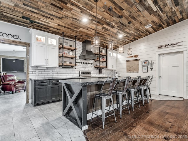 29550 S 4240th Rd, Inola, OK 74036 - kitchen featuring wall chimney range hood, open shelves, white cabinetry, backsplash, and wooden walls