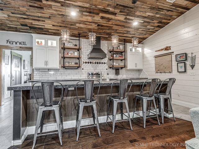 29550 S 4240th Rd, Inola, OK 74036 - bar area with wall chimney range hood, backsplash, hanging light fixtures, baseboards, and wooden walls