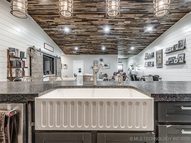 29550 S 4240th Rd, Inola, OK 74036 - kitchen featuring lofted ceiling, a sink, wood walls, and dark countertops