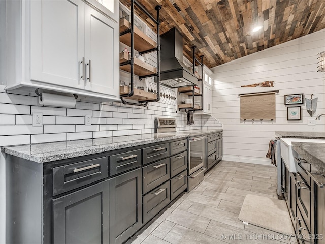 29550 S 4240th Rd, Inola, OK 74036 - kitchen featuring stainless steel electric stove, wall chimney range hood, vaulted ceiling, wooden ceiling, and white cabinetry