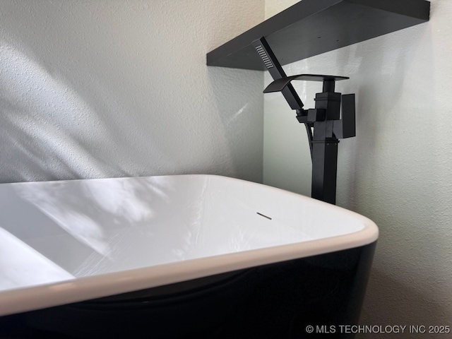 618 E Gentry Ave, Checotah, OK 74426 - bathroom view of a freestanding tub and a textured wall