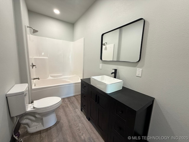 618 E Gentry Ave, Checotah, OK 74426 - full bathroom with wood finished floors, toilet, vanity, and tub / shower combination
