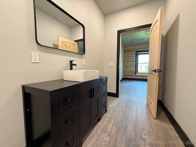 618 E Gentry Ave, Checotah, OK 74426 - bathroom featuring wood finished floors, vanity, and baseboards