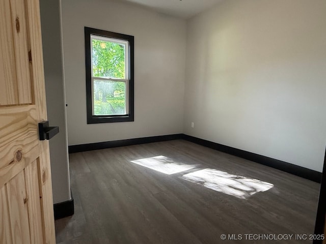 618 E Gentry Ave, Checotah, OK 74426 - empty room featuring dark wood-type flooring and baseboards