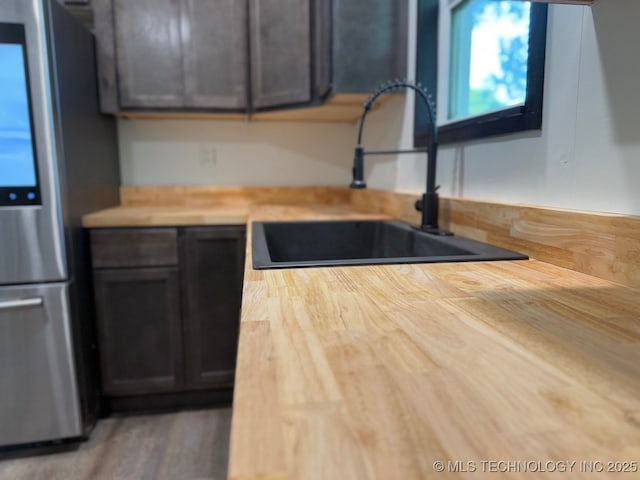 618 E Gentry Ave, Checotah, OK 74426 - kitchen featuring freestanding refrigerator, a sink, and butcher block counters