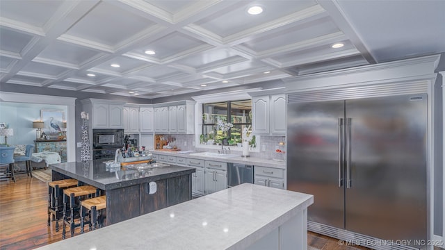 30230 S 562, Afton, OK 74331 - kitchen featuring appliances with stainless steel finishes, a center island, a breakfast bar area, dark wood finished floors, and decorative backsplash