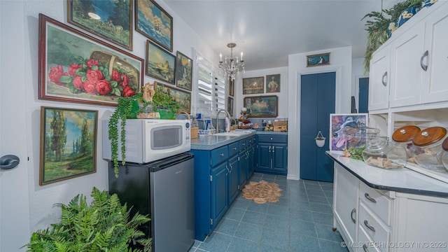 30230 S 562, Afton, OK 74331 - kitchen featuring blue cabinets, white microwave, a sink, a chandelier, and white cabinets