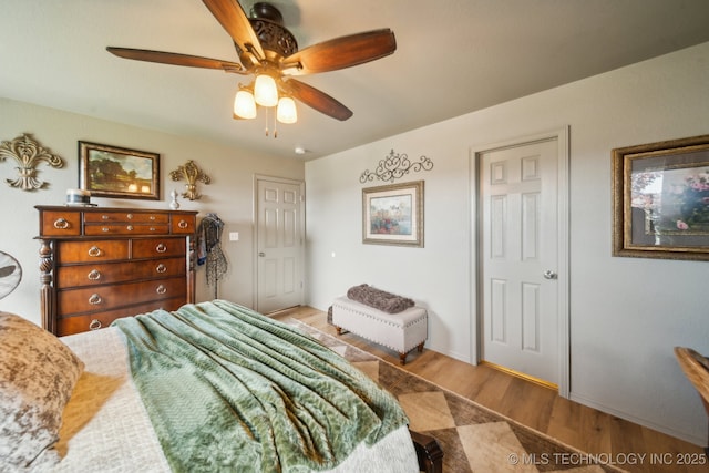 bedroom featuring wood finished floors, a ceiling fan, and baseboards