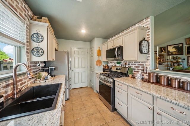 kitchen featuring stainless steel appliances, a sink, backsplash, light tile patterned flooring, and recessed lighting