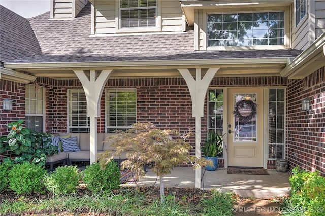 8212 S Delaware Pl, Tulsa, OK 74137 - doorway to property featuring a shingled roof, brick siding, and a patio