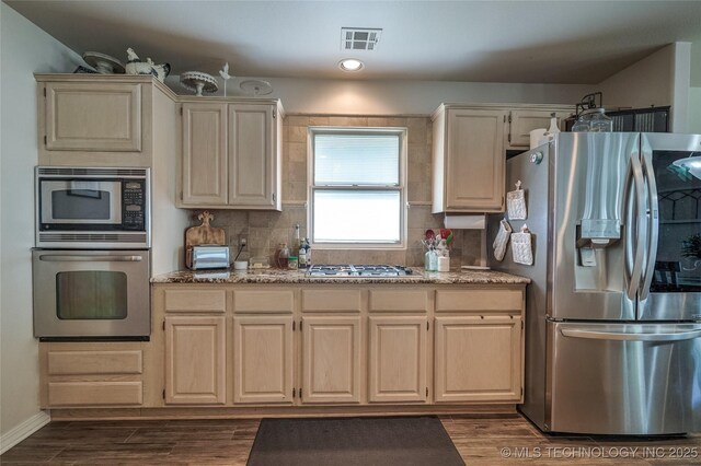 8212 S Delaware Pl, Tulsa, OK 74137 - kitchen featuring appliances with stainless steel finishes, decorative backsplash, dark wood-style flooring, and light stone counters