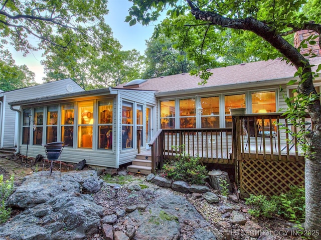 back of house with a wooden deck and a sunroom