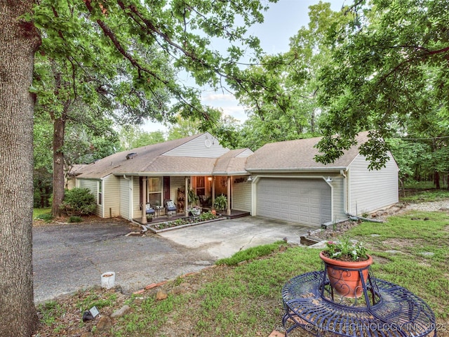 ranch-style house featuring a garage, a porch, concrete driveway, and a shingled roof