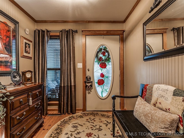 foyer with ornamental molding and light wood finished floors