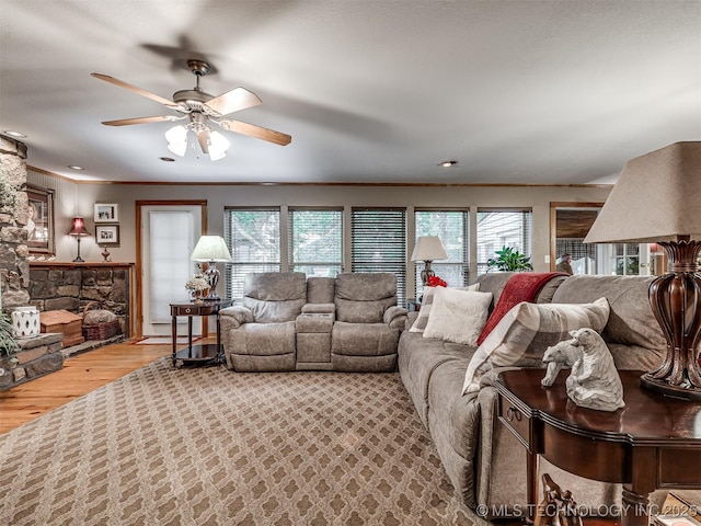 living room with healthy amount of natural light, wood finished floors, a ceiling fan, and crown molding
