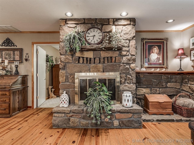living area with ornamental molding, hardwood / wood-style floors, a fireplace, and baseboards