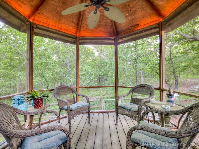 sunroom featuring a ceiling fan, lofted ceiling, and healthy amount of natural light