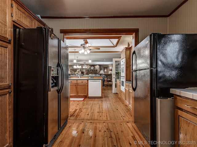 kitchen with freestanding refrigerator, dishwasher, black refrigerator with ice dispenser, light wood-style flooring, and ornamental molding